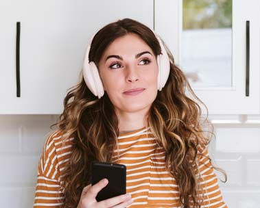 A girl with headphones listens to Audible.