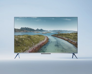 A flat-screen television displaying a scenic coastal landscape with turquoise waters flowing between green shorelines and mountains in the background, set against a light blue backdrop.