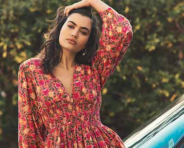Model in a red dress in front of a green background