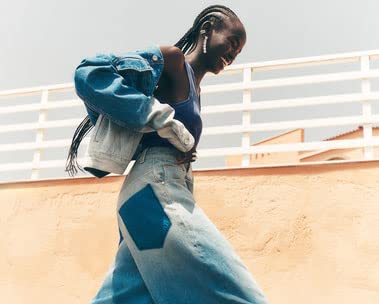 Girl smiling in blue tank top, blue denim jacket and blue jeans