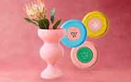 pink vase with flowers and colorful coasters