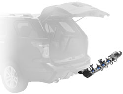 The Thule 9025 Apex four-bike hitch mount carrier in the down position with vehicle hatchback open