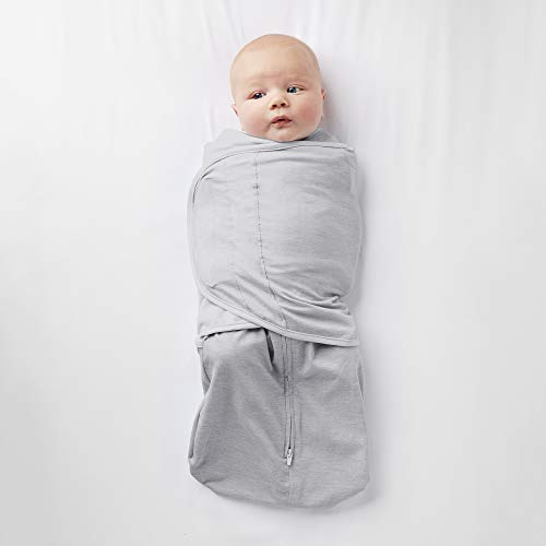 Child sleeping in arms, wearing a cotton hip carrier.