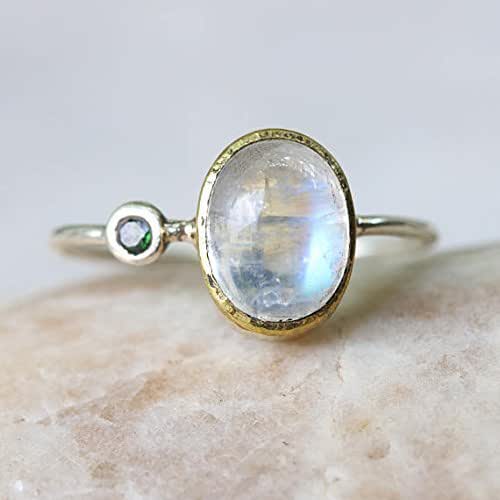 Oval cabochon moonstone ring with tiny greentourmaline on