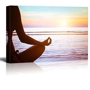 Girl Meditating on a Lake Looking Over The Sunset