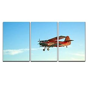 Red Vintage Airplane Flying Against Blue Sky x3 Panels