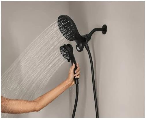 A person's hand holding the detachable handheld shower head, with water flowing from both the handheld and the fixed shower head, demonstrating the dual functionality.