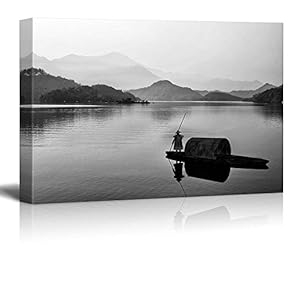 Black and White Canoe with a Man Rowing Down a Lake Towards The Mountains - Canvas Art Home Art - 12x18 inches