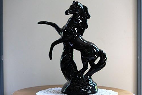 A wild black ceramic stallion with its legs high in the air.