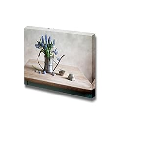 Still Life with Grape Hyacinths Arranged in an Antique Watering Can with Old Moulds on a Rustic Wooden Kitchen Table Wood Framed - Canvas Art Wall Art - 12" x 18"