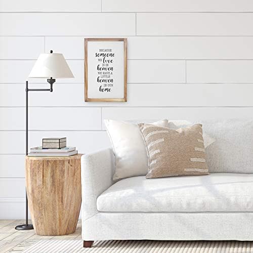 Farmhouse style wooden wall sign with the word "HOME" in distressed white paint and a wreath design.