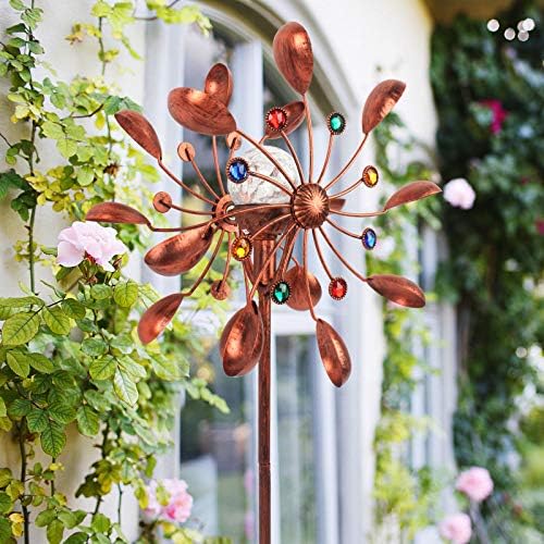 Colorful solar-powered wind spinners spinning in a backyard setting.
