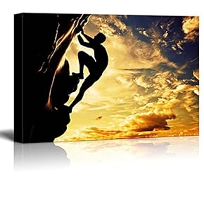 A Silhouette of a Man Climbing on Rock Mountain Cliff at Sunset Concept of Bravery Determination - Canvas Art Wall Art - 12" x 18"