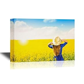 Beautiful Woman in Blue Dress in Summer Canola Field