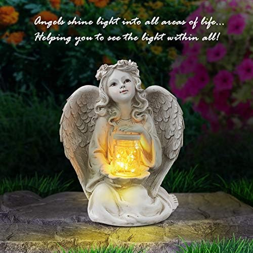 Solar guardian angel statue in a garden setting.