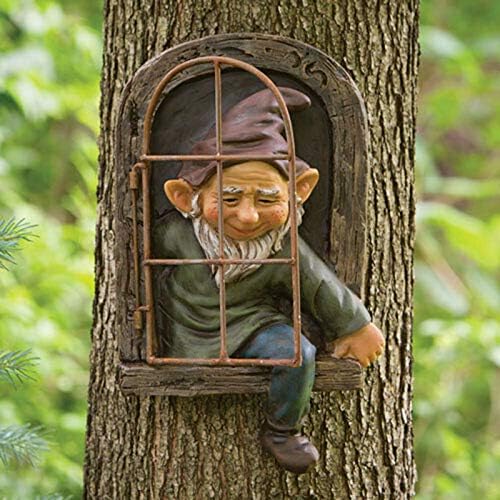 Garden gnome statue under a tree, adding whimsical charm to the backyard.