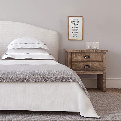 Farmhouse style wooden wall sign with the word "HOME" in distressed white paint, surrounded by a wreath design.