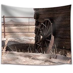 A Wagon Wheel Resting Against an Old Cabin with Mountains in The Distance - Fabric Wall Tapestry Home Decor - 51x60 inches