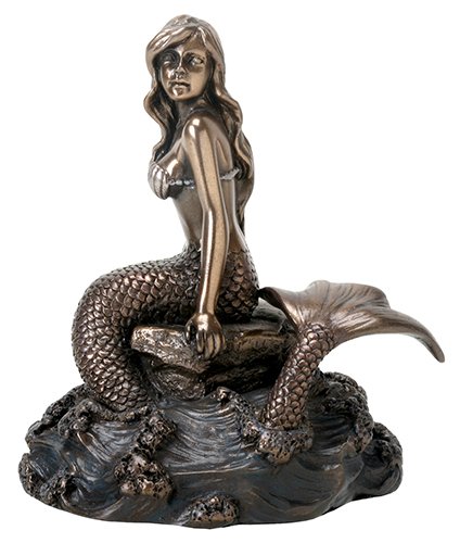 Bronze colored ocean mermaid on rock with tail in water…