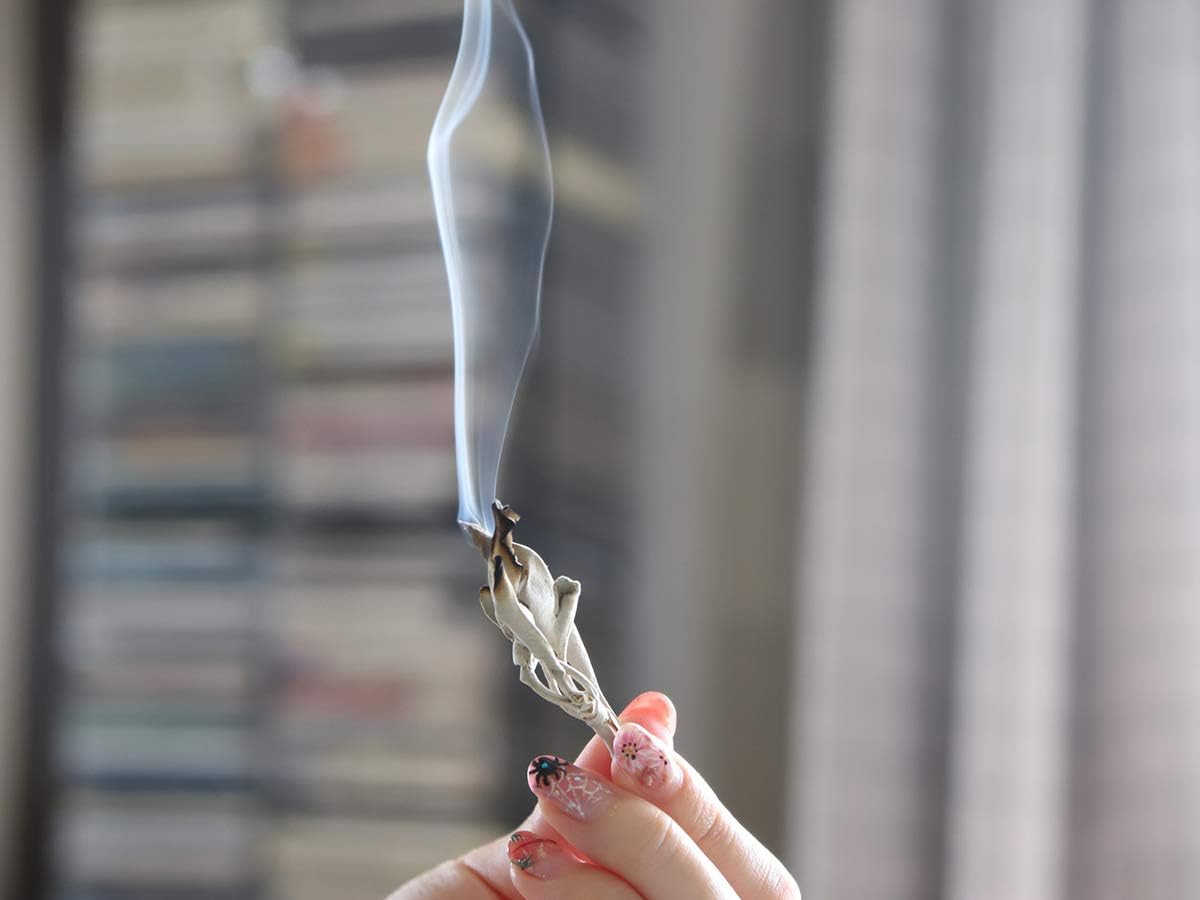 火をつけたホワイトセージを持っている手元