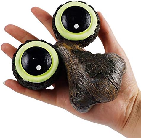 Sculpture of a tree face with eyes and a mouth, acting as a bird feeder.