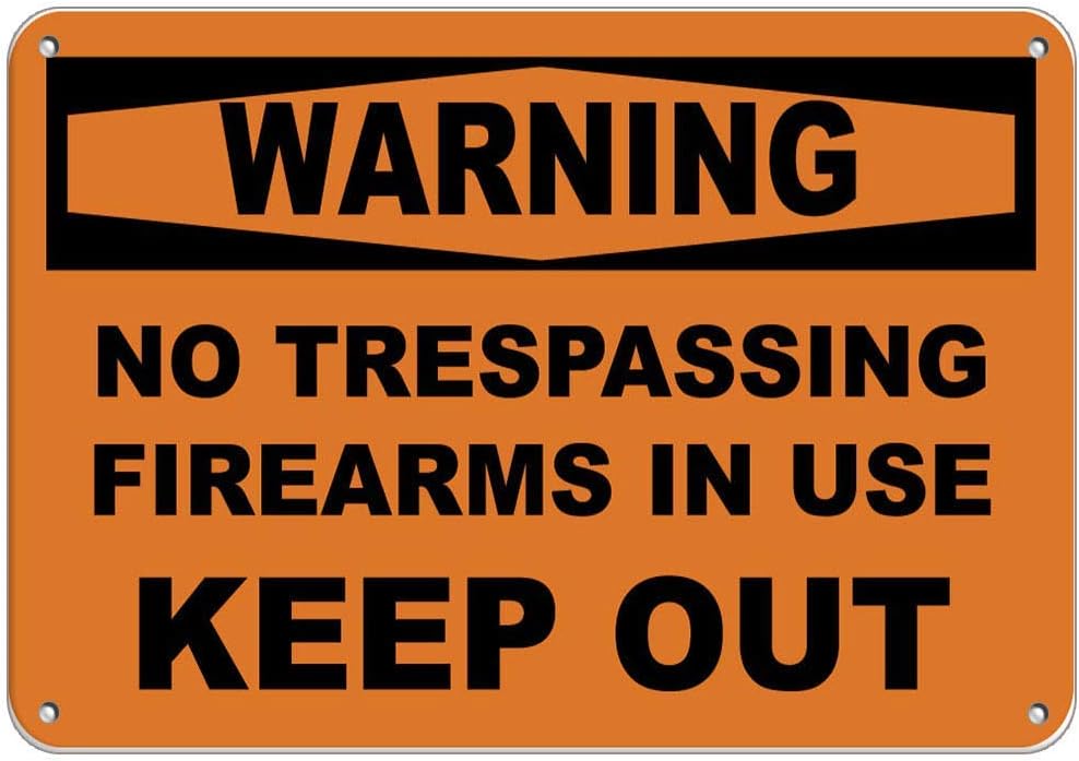 Señal de metal con texto en inglés "No Trespassing Firearmas in use