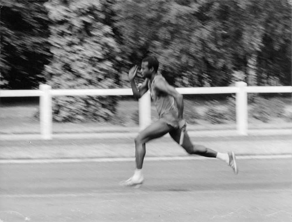 Vintage photo of A man running during a competition for 100 meters world record, 1967.