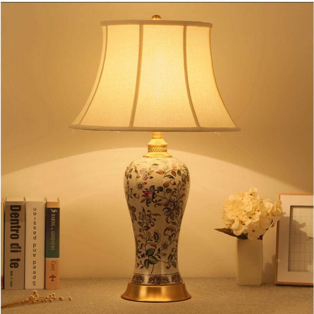 white ceramic lamp with flower on base