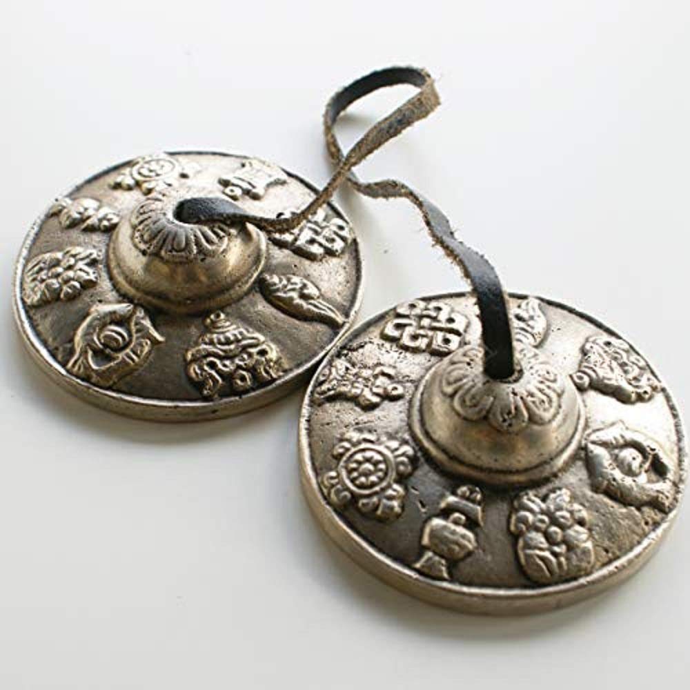 Tibetan Buddhist Astamangala Hand Bells on Leather Cord; 63mm Diamteter; embossed with the 8 Buddhist Symbols of Happiness. Notes pitched at either E or F. Tingsha come in a Drawstring Carry Pouch - sold by Spiritual Gifts. Usually dispatched within 2 working days.
