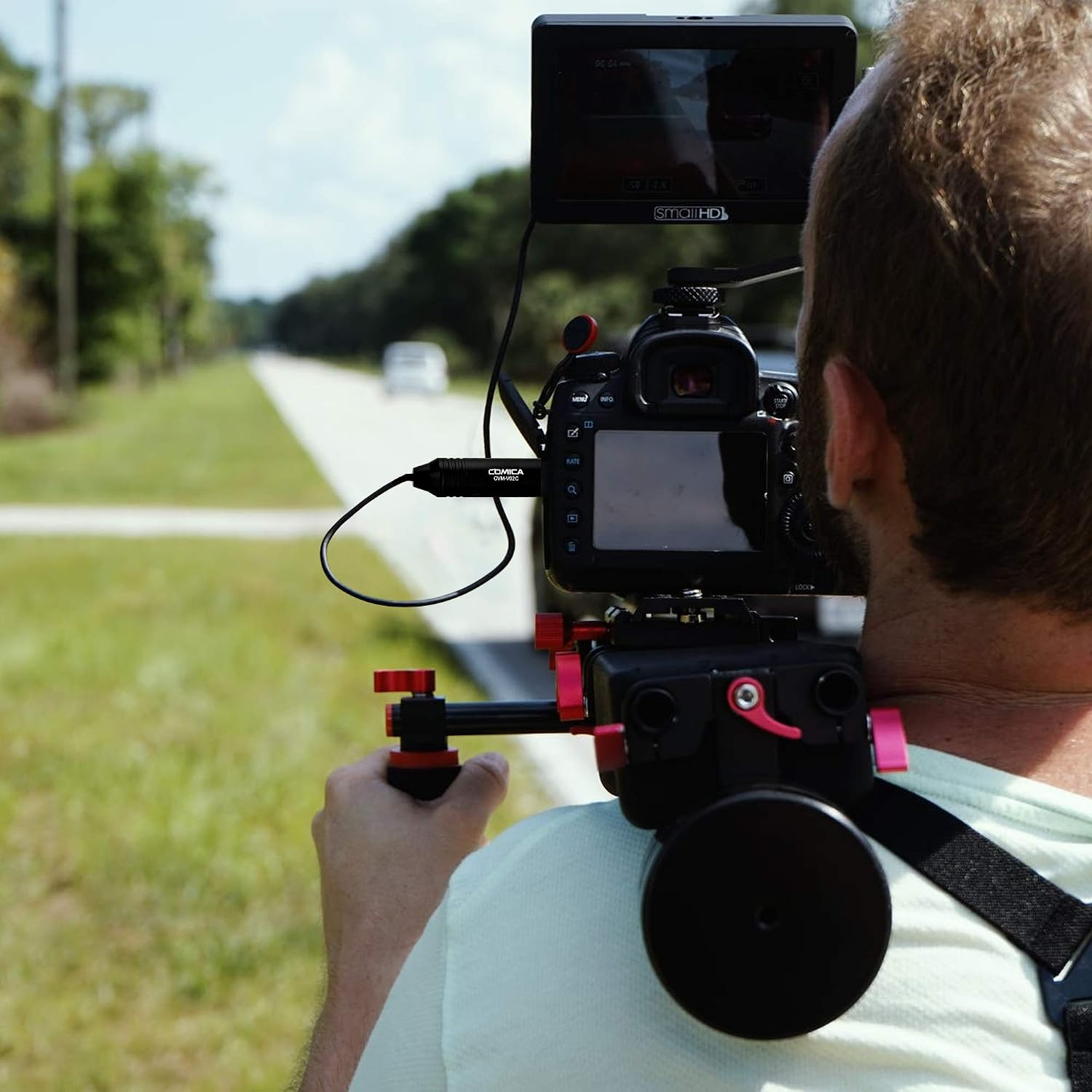 COMICA CVM-V02C microphone connected to a camera rig during outdoor filming.