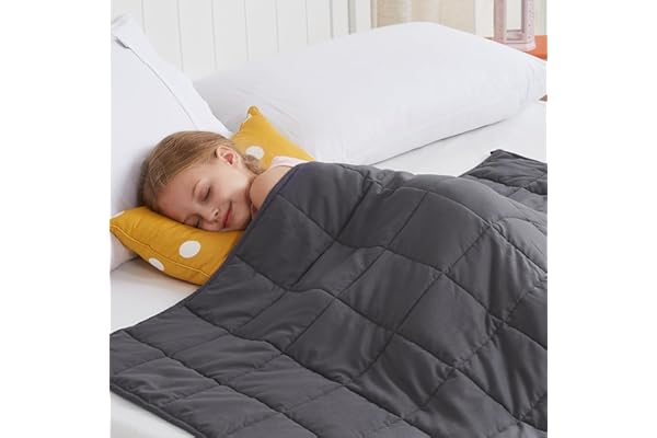 Child peacefully sleeping under a grey weighted blanket