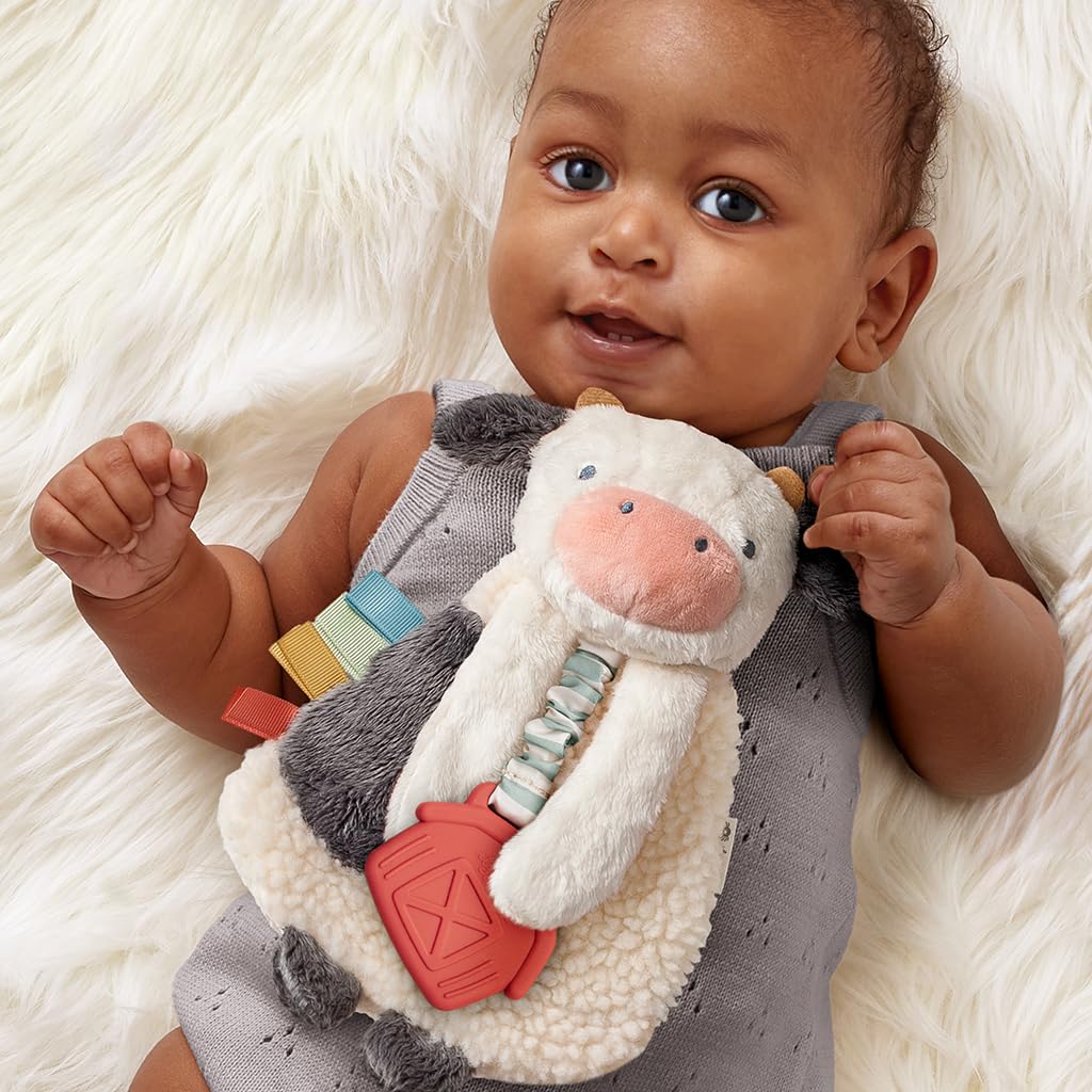 Itzy Ritzy - Itzy Lovey Including Teether - Baby Lovey with Teether, Textured Ribbons & Dangle Arms - Features Crinkle Sound, Sherpa Fabric and Minky Plush (Cow)