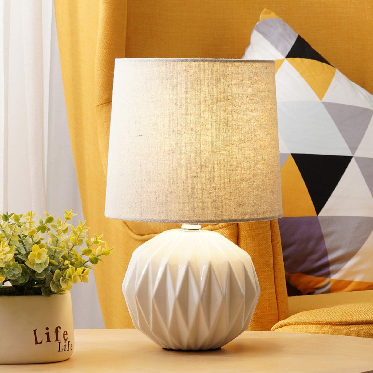 white ceramic lamp with flower on base