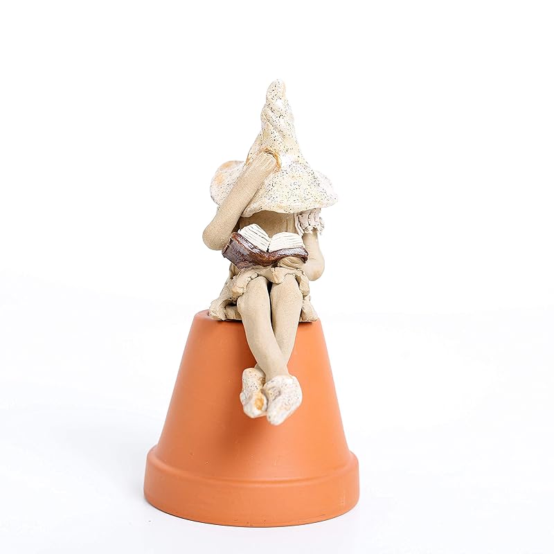 Fairy garden fairy figurine, plant pot ornament reading her book. Hand