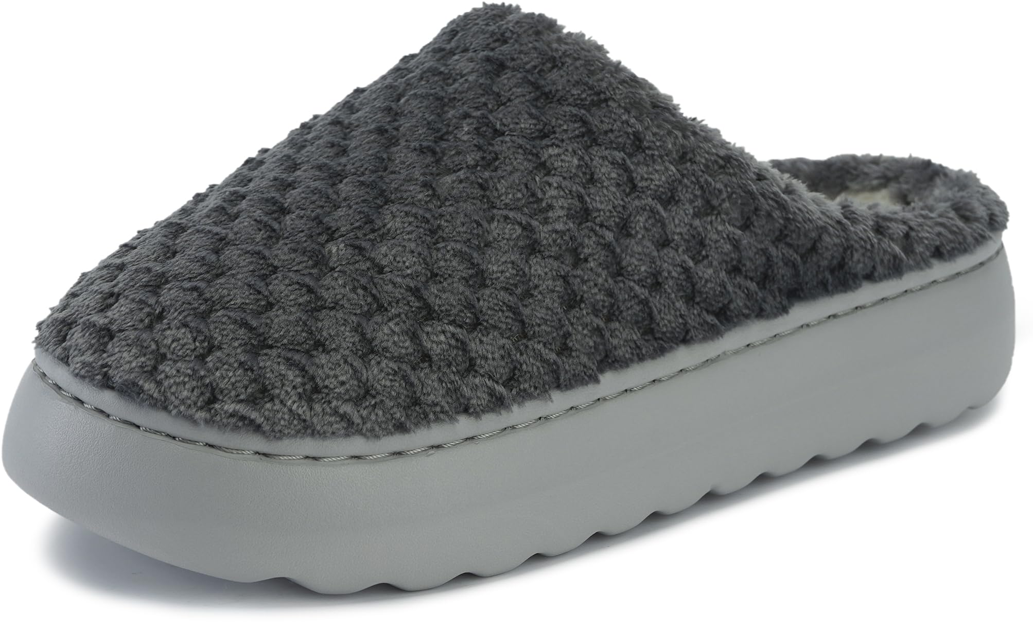 A pair of memory foam slippers on a hardwood floor, with a soft, cushioned insole