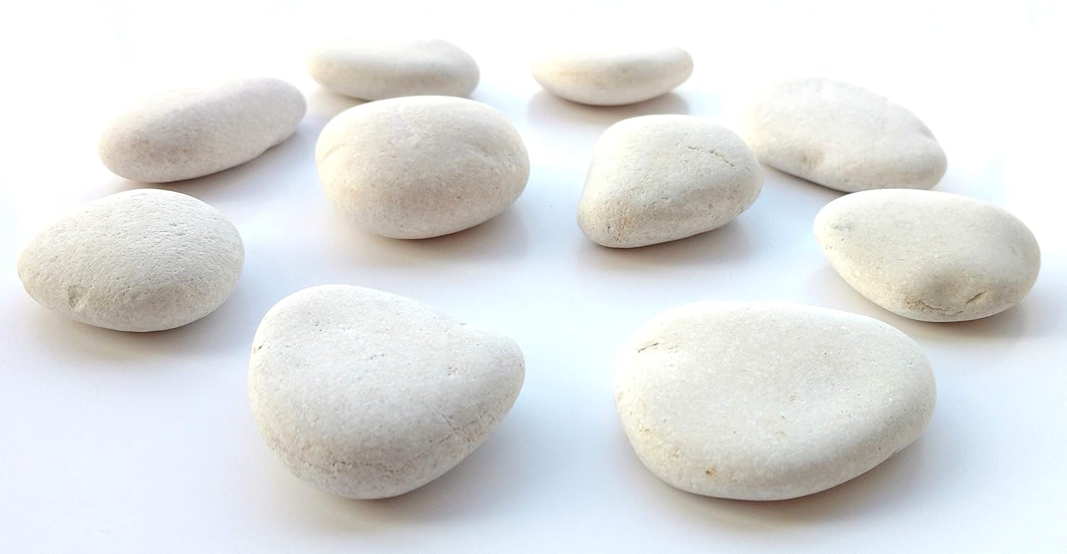 A group of white rocks for rock painting sitting on a white table. 