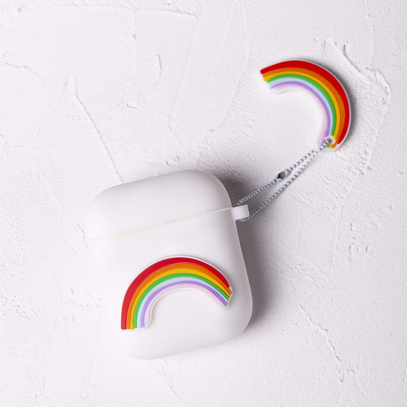 White silicone case for Airpods 1 & 2 with 3D piece of colorful rainbows, design by Lucía Be