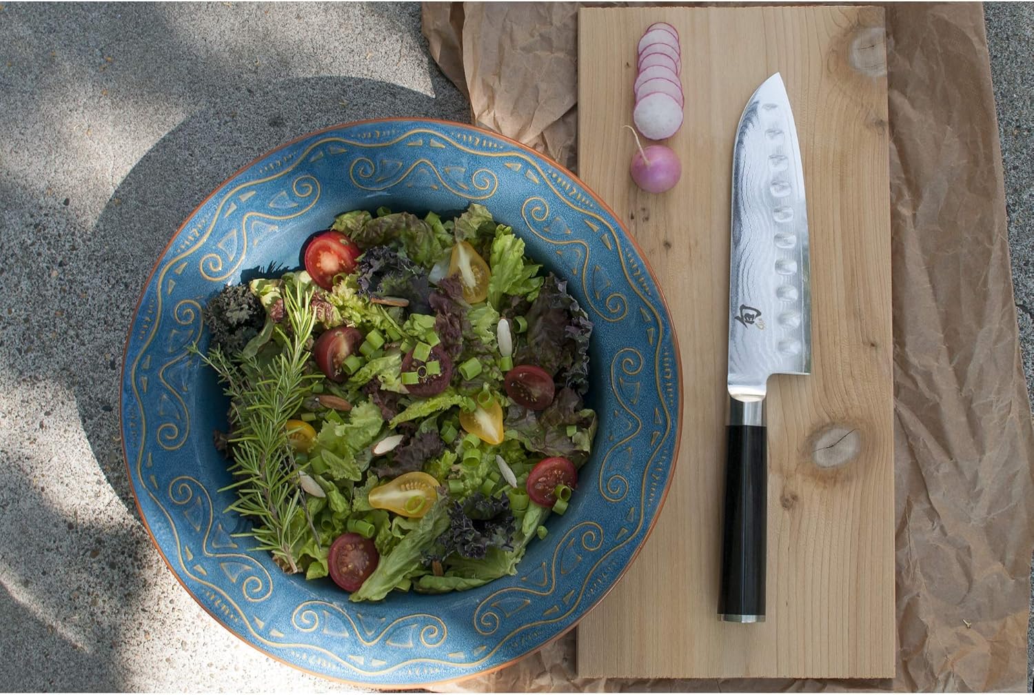 まな板に置いてある三徳包丁と大皿に盛り付けられた野菜サラダ