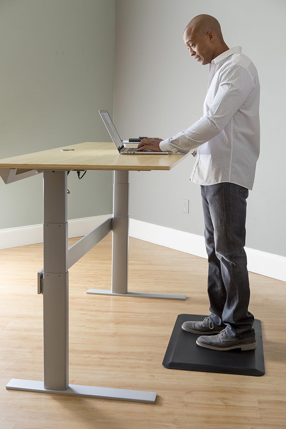 an image with a guy in an office at a stand up desk - on an anti-fatigue mat