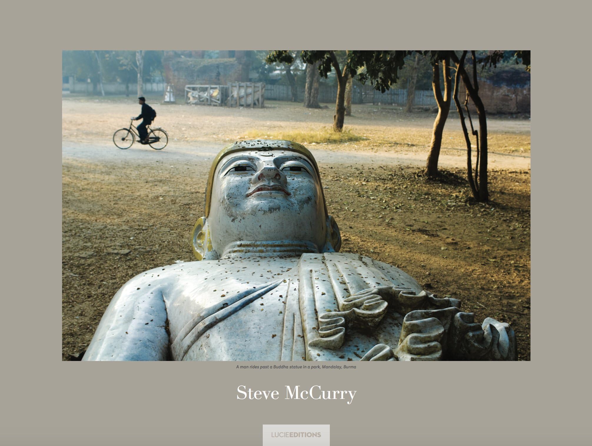 Signed NatGeo Poster "A man rides past a Buddha statue in a park, Mandalay, Burma" by Steve McCurry