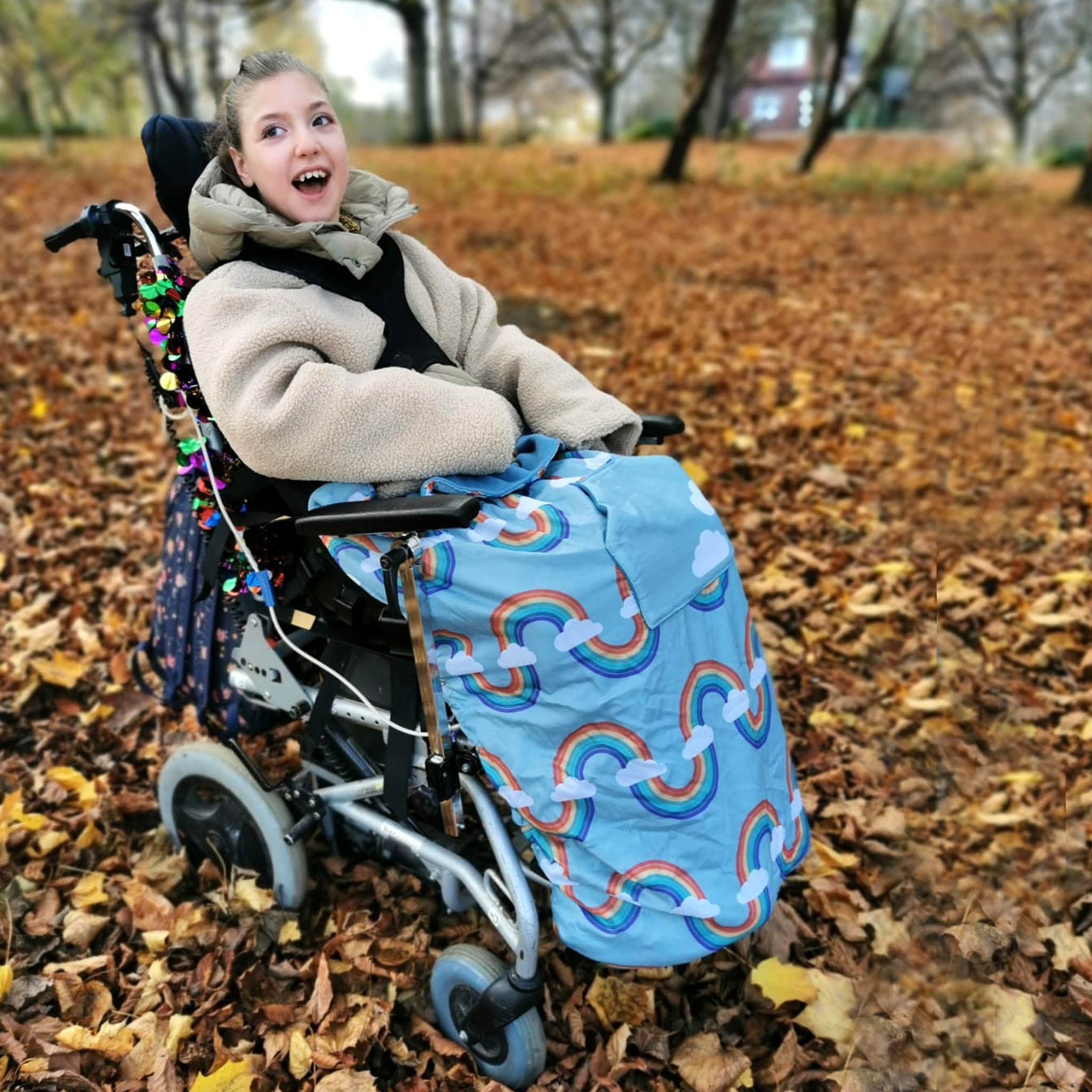Bundlebean Children’s Wheelchair Cosy – Fleece‑Backed Waterproof Nylon, Front Hand-Warming Pouch, Adjustable Straps – Universal Fit for Wheelchair and Special Needs Buggy - Child Size (Blue/Rainbow)