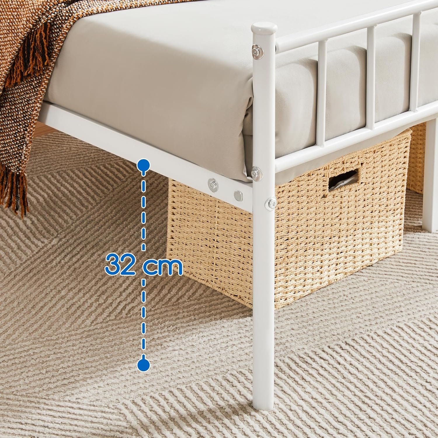 Fully assembled white metal bed frame with a mattress, bedding, and two storage baskets neatly placed underneath.