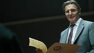 Leslie Nielsen as Frank Drebin standing in an interrogation room in the Naked Gun game.