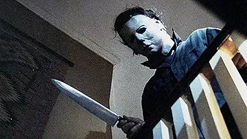 Michael Myers (Nick Castle) breaks into a closet to kill Laurie Strode (Jamie Lee Curtis) in John Carpenter's Halloween (1978).