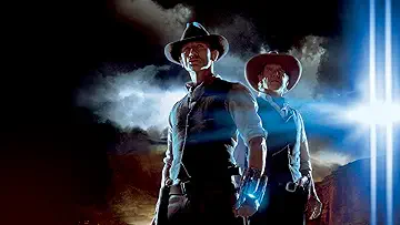 Daniel Craig as Jake Lonergan stands in a Western desert with an alien weapon on his wrist in the poster for the Cowboys and Aliens game.