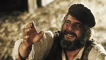 Tevye (Chaim Topol) reaches up to the sky during 'If I Were a Rich Man,' in the Fiddler on the Roof game.