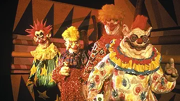 A giant killer klown looms over a theme park on the poster for the Killer Klowns from Outer Space game.