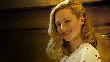 Laura Linney as Hannah Gill/Meryl Berbank smiles at Jim Carrey's Truman Burbank, in the Truman Show game.