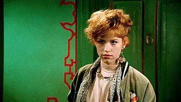 Molly Ringwald's Andie Walsh, John Cryer's Duckie Dale, and Andrew McCarthy's Blane McDonagh pose on the black-and-white poster for the Pretty in Pink game.