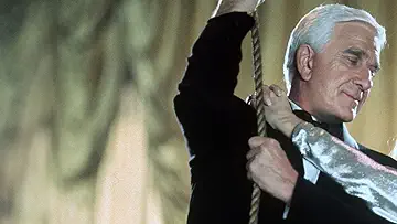 Leslie Nielsen's Frank Drebin aims at nothing on the poster for the Naked Gun 33⅓: The Final Insult game